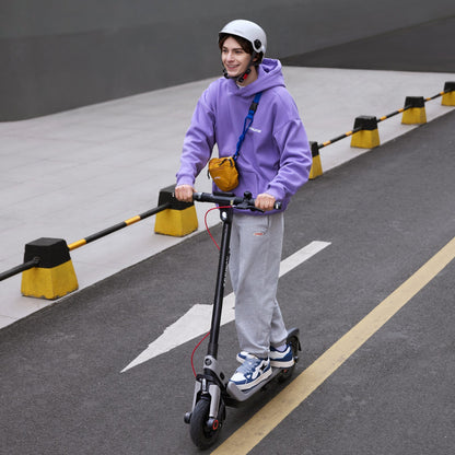 Helmeted rider using a Segway E3 Pro electric scooter in an urban setting