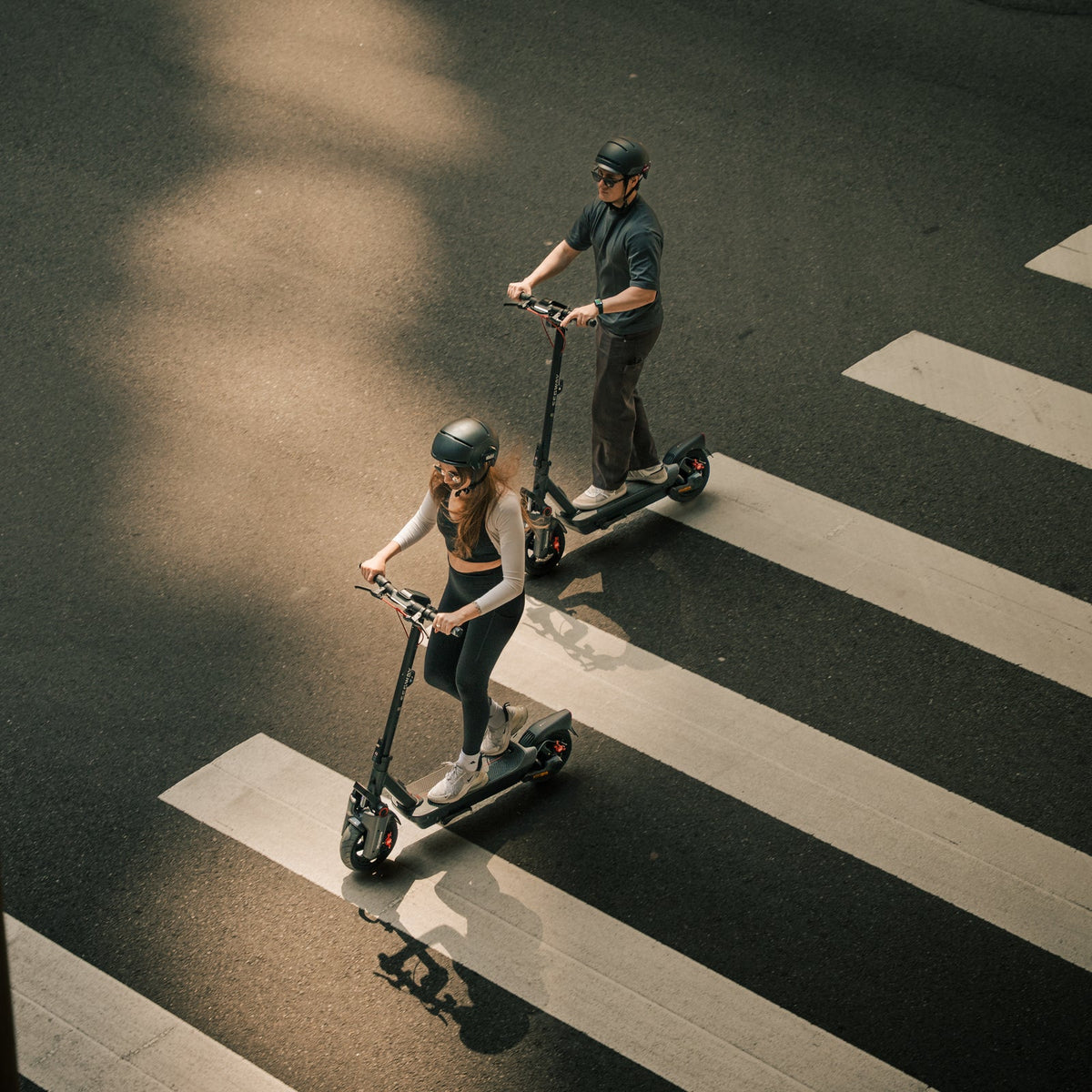 Overhead view of two helmeted riders on Segway MAX G3 scooters