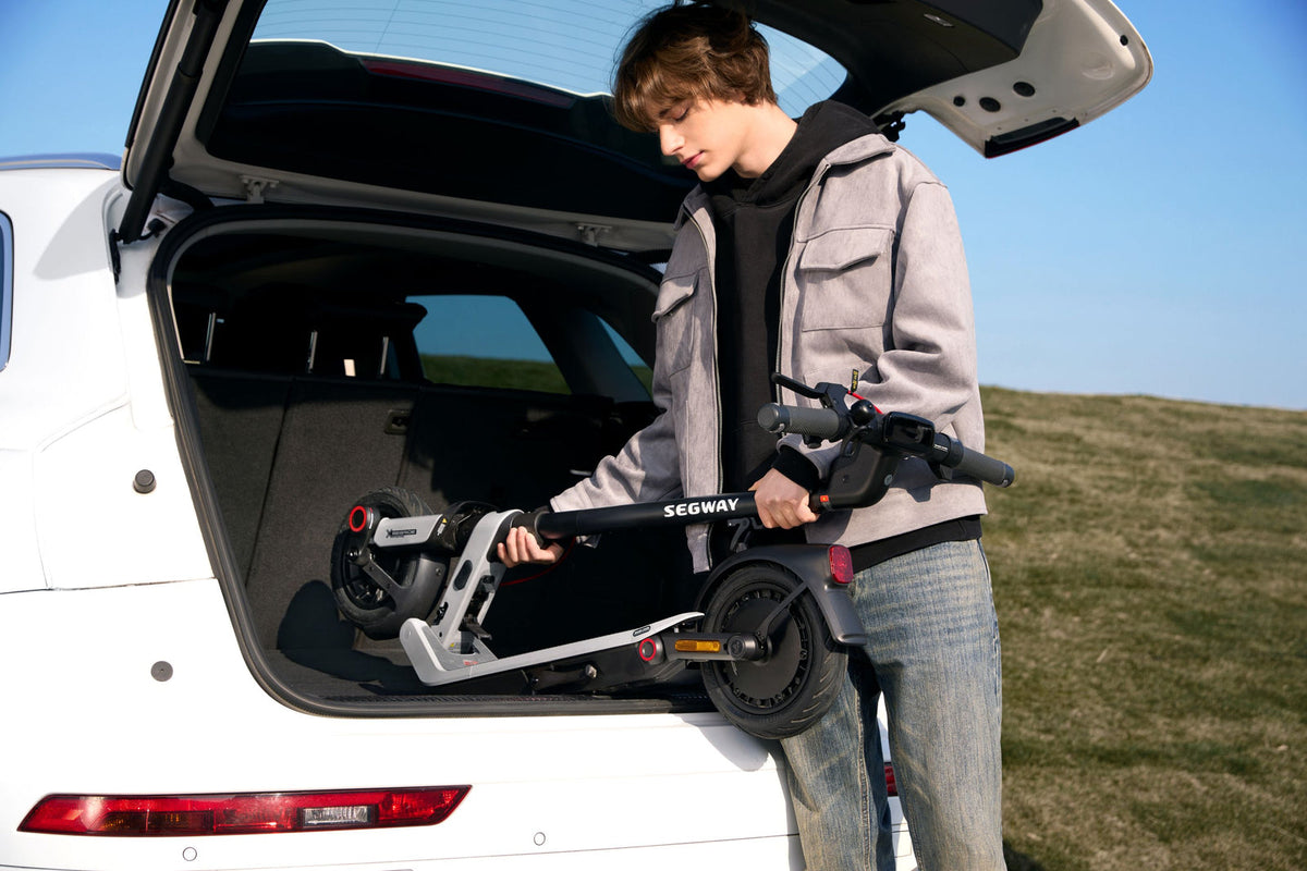 Folded Segway E3 Pro being lifted into the boot of a car