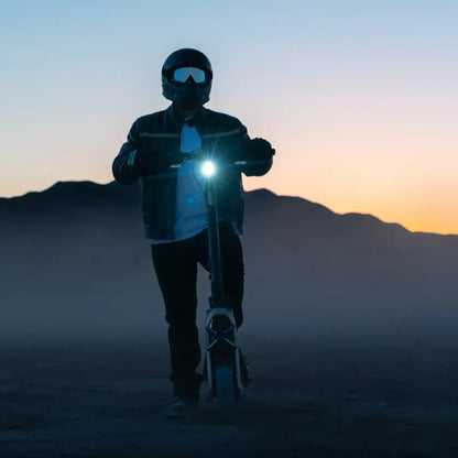 Segway Ninebot GT3 electric scooter — rider demonstrating the headlight at dusk