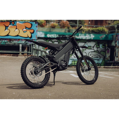 Talaria XXX PRO electric dirt bike parked beside a graffiti wall.