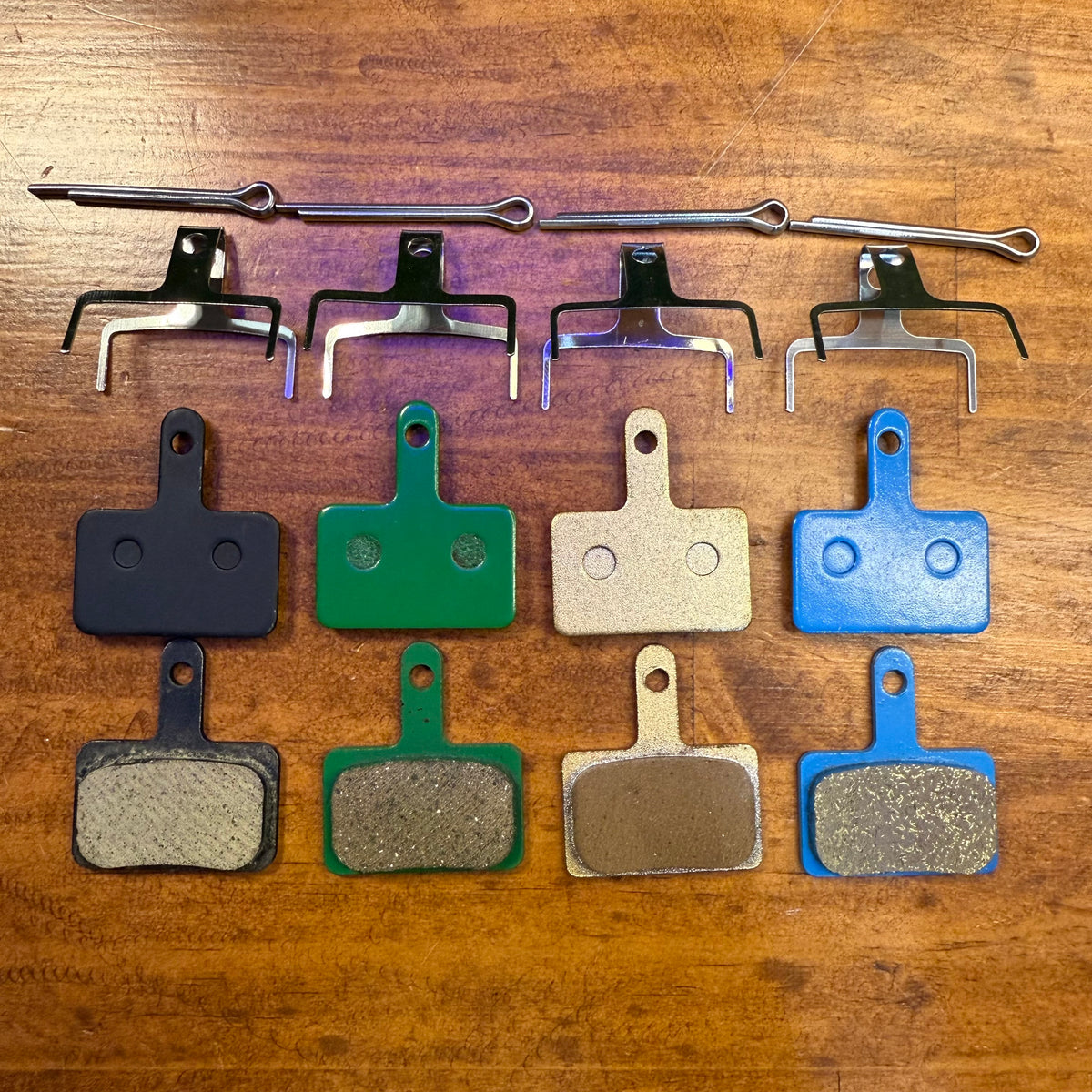 Type 1 rectangular brake pad sets in black, green, gold and blue with springs and retaining pins